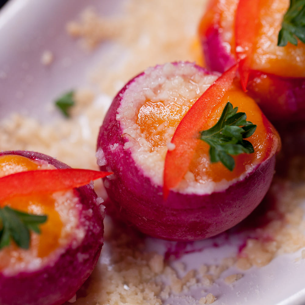 Hollowed radishes filled with a creamy mousse, topped with pepper curls and parsley.